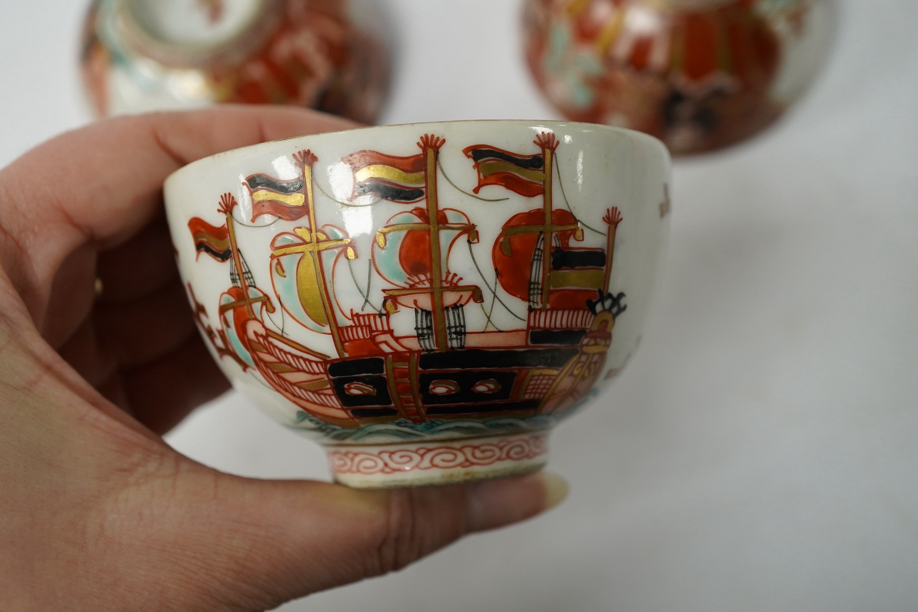 Three Imari ‘Black Ship’ teabowls, Meiji period, 8.5cm in diameter. Condition - good